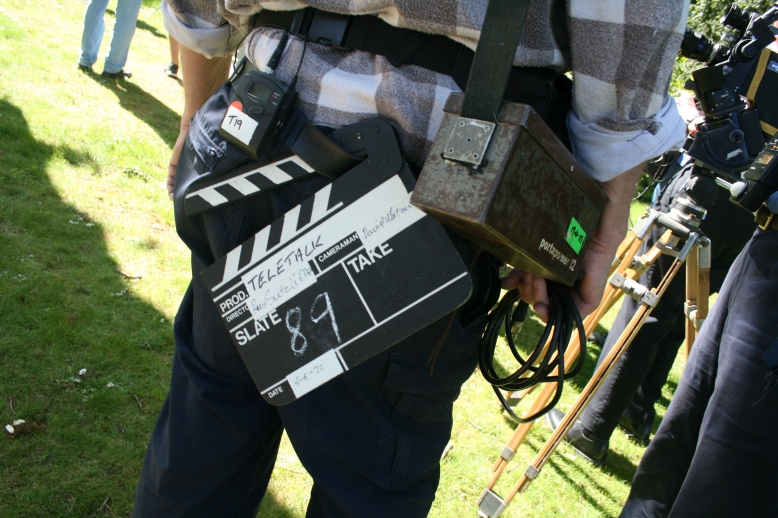 Assistant camera operator John Adderley with a clapperboard